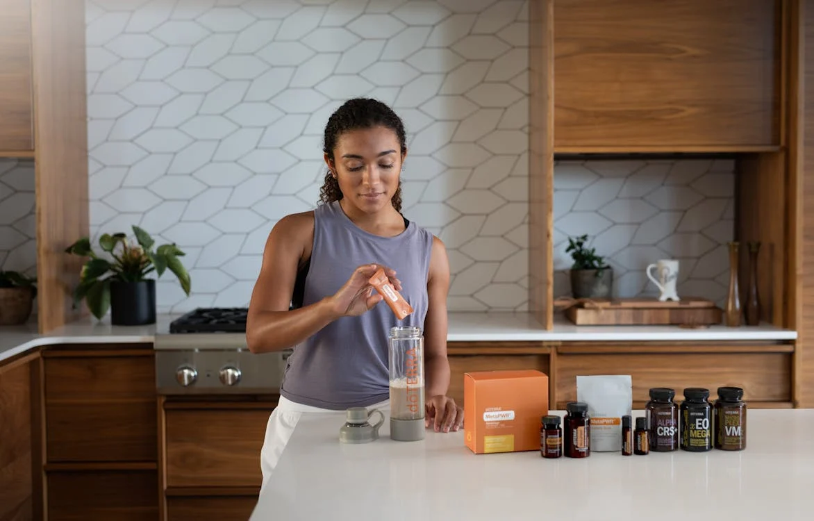 Various supplement bottles lined up on a kitchen counter.